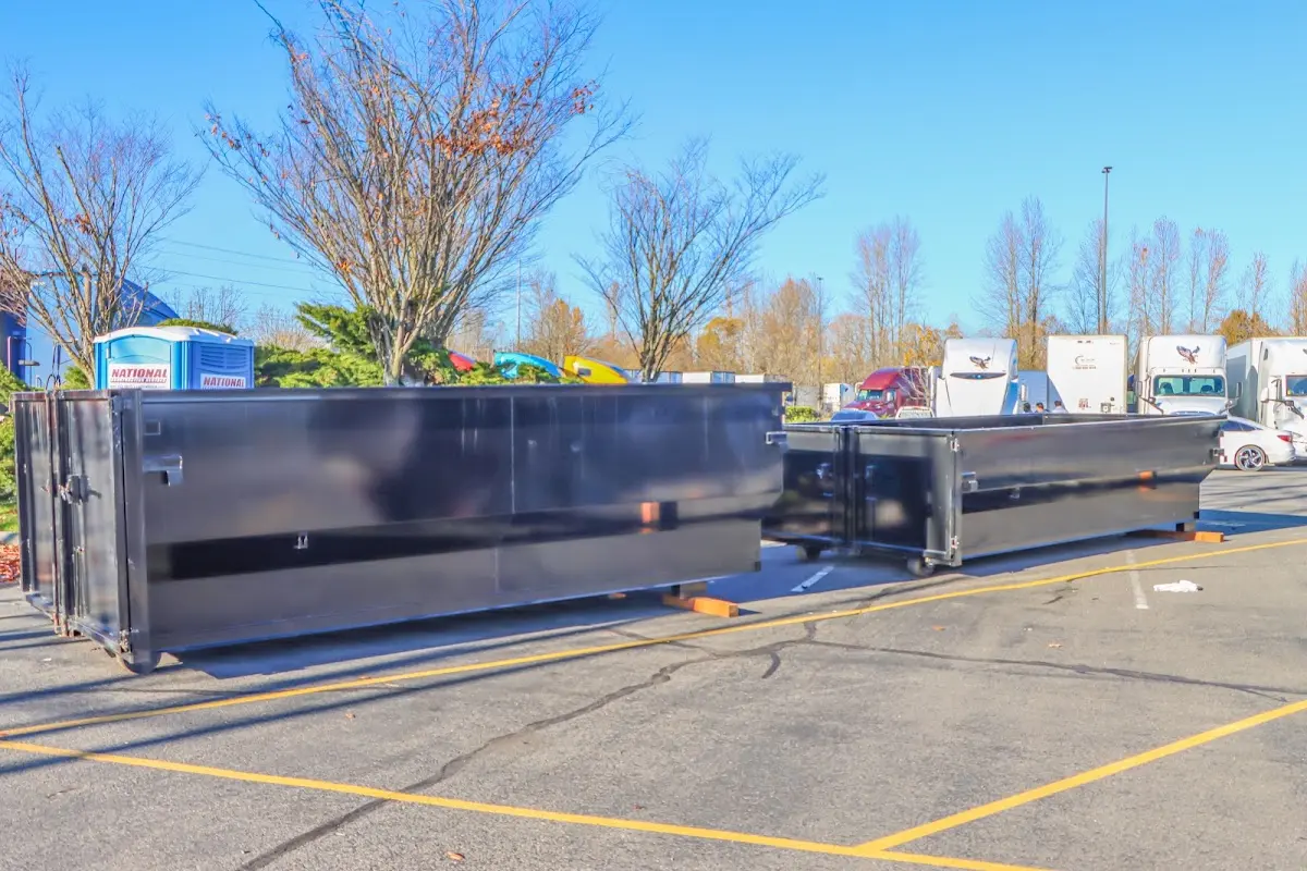 Professional dumpster rental service with roll-off container on residential driveway in Addis